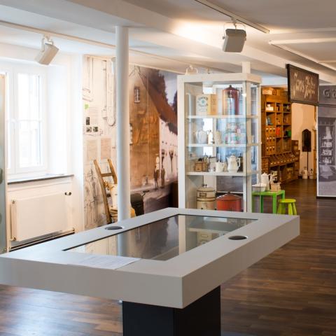 Blick ins Museum mit Ausstellungsstücken und Multimediatisch