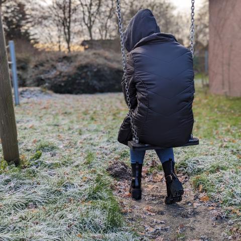 Jugendliche sitzt auf Schaukel