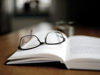Brille liegt auf offenem Buch