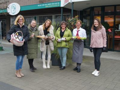 Frauen stehen nebeneinander und präsentieren Waren