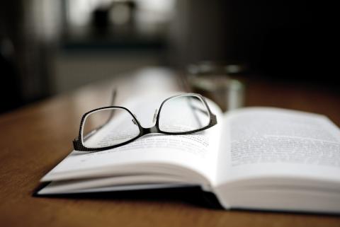 Brille liegt auf offenem Buch