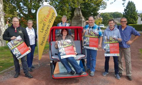 Gruppenfoto mit Werbeplakaten