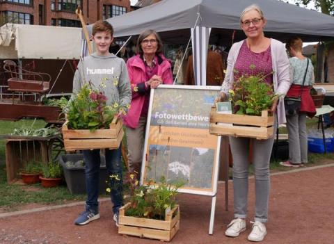 Mitarbeiterin der Stadtverwaltung überreicht Gewinne des Fotowettbewerbs