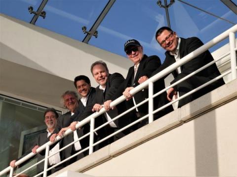 Bandmitglieder nebeneinander auf Empore