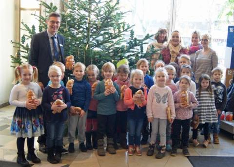 Kindergruppe mit Erziehern und Bürgermeister vor Weihnachtsbaum im Rathaus