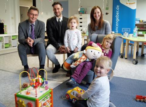 3 Erwachsene und 3 Kinder mit Spielzeug
