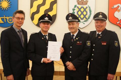 Bürgermeister und drei Feuerwehrmänner