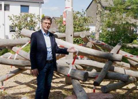Bürgermeister hält Absperrband am Klettergerüst