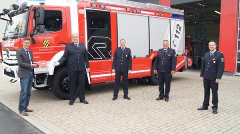 5 Männer vor Feuerwehrfahrzeug