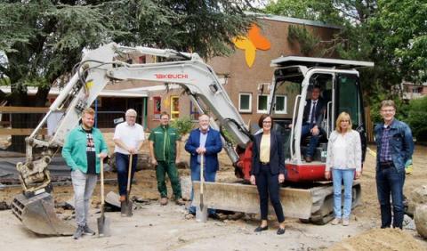 Gruppenfoto vor Baustelle mit Bagger