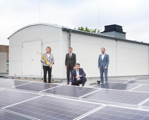 Vier Personen auf Dach mit Photovoltaikanlage