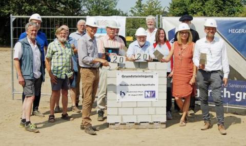 Gruppenbild rund um halbfertige Mauer