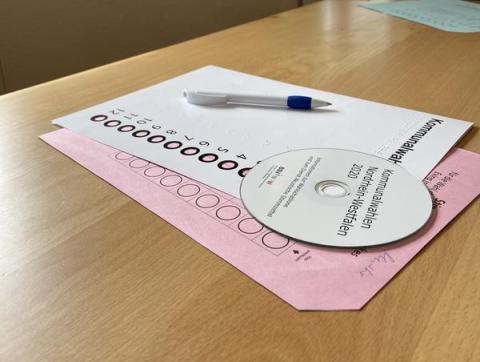 CD, Zettel und Stift auf Tisch