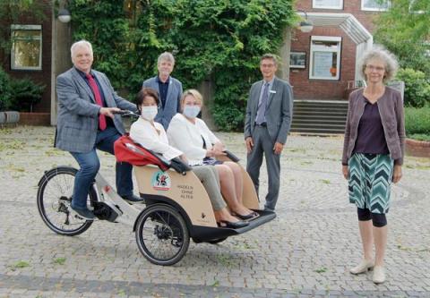 Fahrradrikscha und 7 Personen darum verteilt