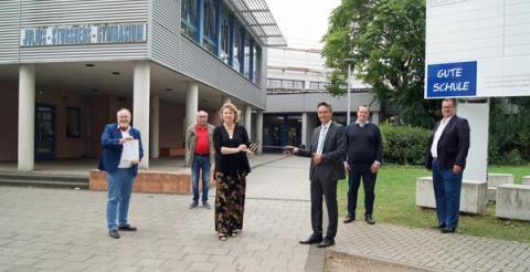 Menschen vor Schule mit Schlüssel