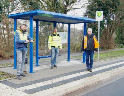 3 Männer vor Bushaltestelle mit Wartehäuschen