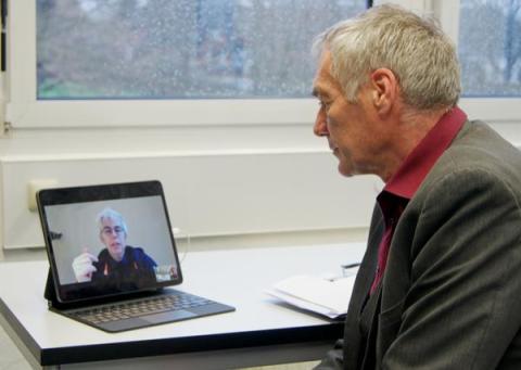 Mann bei Videokonferenz am Tablet