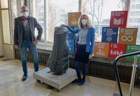 Ein Mann und eine Frau vor Statue