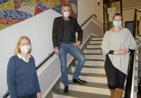 3 Personen auf Treppe im Rathaus