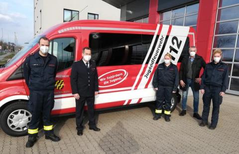 5 Personen mit Maske vor Mannschaftstransportfahrzeug
