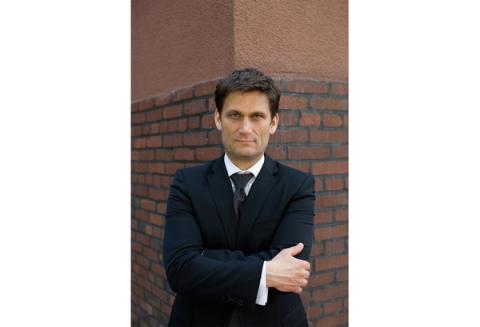 Mann steht an Mauer gelehnt