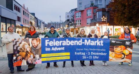 Menschen stehen hinter Werbebanner und halten es fest