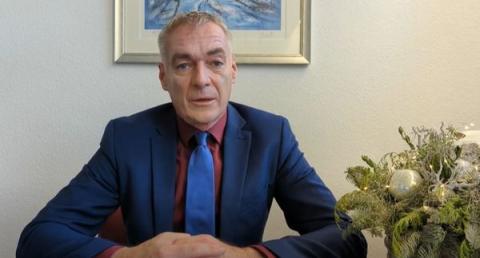 Mann sitzt am TIsch und spricht
