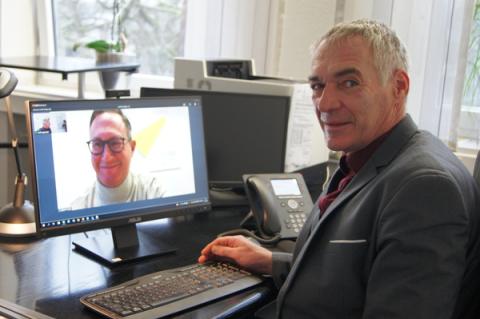 Mann vor Computerbildschirm in Videokonferenz mit weiterem Mann