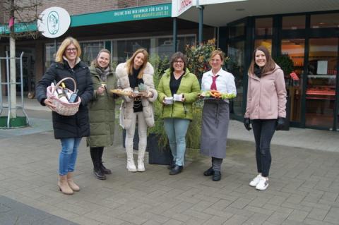 Frauen stehen nebeneinander und präsentieren Waren