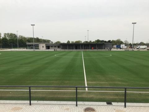 Fußballfeld, im Hintergrund Baustelle