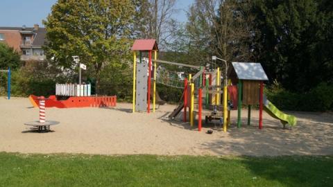 Spielplatz mit Spielgeräten auf Sandfläche