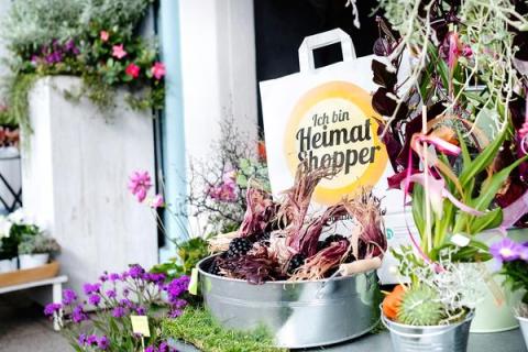 Papiertasche der Aktion, umgeben von Blumen