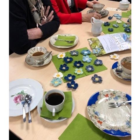 Kaffeetafel geschmückt mit gehäkelten Blüten