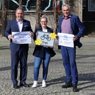 3 Personen halten Werbeschilder