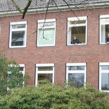 Zwei Menschen schauen aus Fenstern des Rathauses Zwei Menschen schauen aus Fenstern des Rathauses