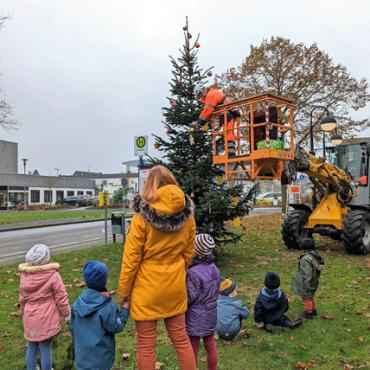 Kinder und Erzieherin betrachten Weihnachtsbaum Kinder und Erzieherin betrachten Weihnachtsbaum
