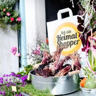 Papiertasche der Aktion, umgeben von Blumen Papiertasche der Aktion, umgeben von Blumen